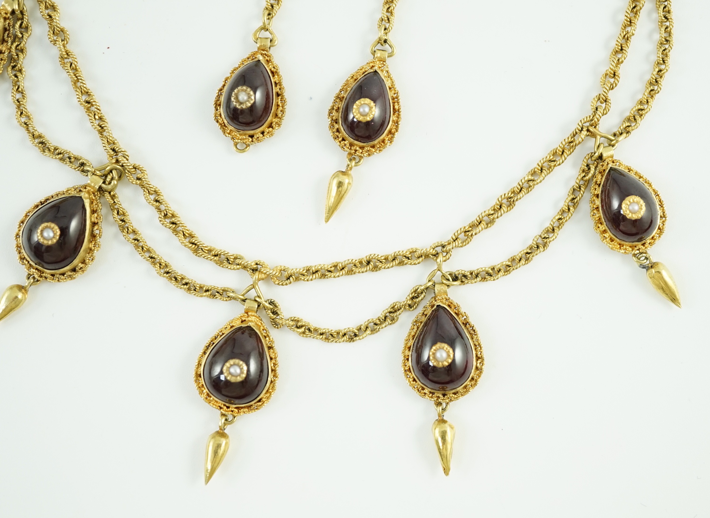 A 19th century Indian gold, garnet and seed pearl set demi parure, comprising and a drop fringe necklace and pair of matching ear clips